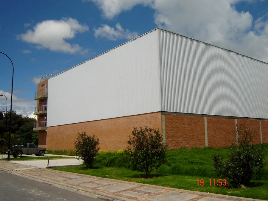 Bodega industrial con fachada en ladrillo y cerramiento metálico