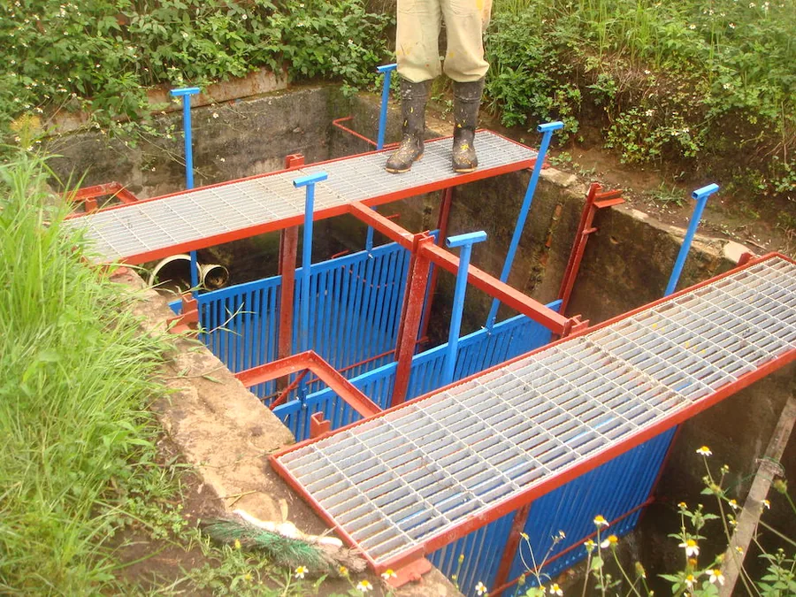 Criba de sólidos y pasarelas metálicas en planta de tratamiento de aguas residuales