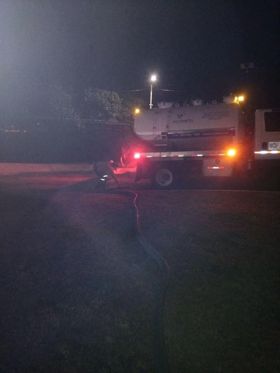 Equipo vactor operando a las 5:30 a. m. durante la succión de aguas residuales provenientes de un pozo.